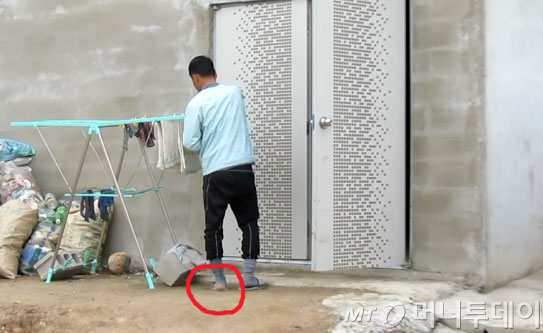 지난 1월24일 염전 노예로 끌려가 노역에 동원된 김모씨(40)의 모습. 한겨울에도 낡은 양말이 구멍 나 있다. 뒤편의 건물은 생활을 하던 자재창고. /사진=서울 구로경찰서
