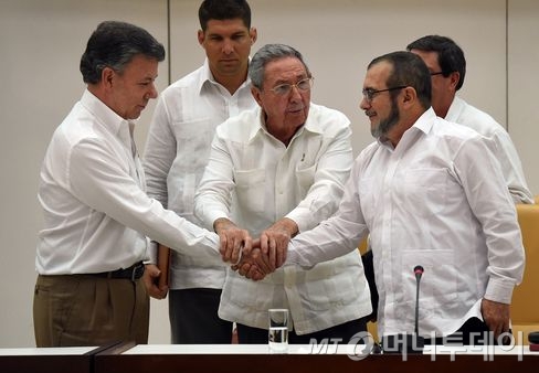 평화협정을 하고 악수를 하는 산토스 대통령(왼쪽)과 FARC 지도자  로드리고 론도뇨. /사진=블룸버그