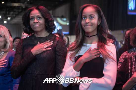 10일(현지시간) 미국 일리노이주 시카고의 맥코믹플레이스에서 버락 오바마 미국 대통령의 고별연설에 앞서 영부인 미셸 여사와 장녀 말리아가 미국 국가를 들으며 가슴에 손을 얹고 있다./사진=AFP