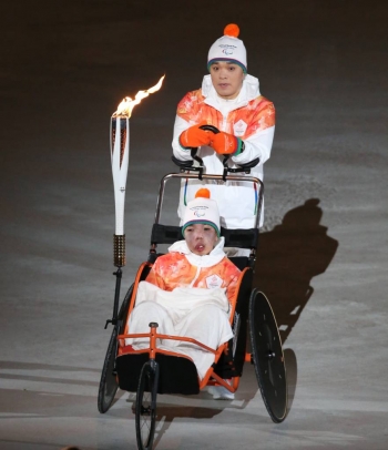【평창=뉴시스】김경목 기자 = 2018평창동계패럴림픽대회 개막일인 9일 오후 강원 평창군 대관령면 평창올림픽스타디움에서 개회식이 열린 가운데 철인 3종에 도전한 불굴의 아버지 박지훈 씨가 6가지 희소난치병을 지닌 아들 박은총군과 함께 성화를 봉송하고 있다. 2018.03.09.    photo31@newsis.com  <저작권자ⓒ 공감언론 뉴시스통신사. 무단전재-재배포 금지.>