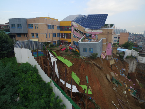  7일 오전 서울 동작구 상도초등학교 내 상도유치원이 옆 공사장 지반 침하로 기울어져있다.   6일 밤 서울 동작구의 한 공동주택 공사 현장에서 흙막이가 붕괴되며 지반이 침하돼 인근 상도초등학교 내 유치원 건물이 기울어지는 사고가 발생했다. 동작소방서는 이날 오후 11시22분쯤 신고를 접수하고 동작구청 등과 함께 현장을 통제하고 있다고 밝혔다. 2018.9.7/뉴스1  <저작권자 © 뉴스1코리아, 무단전재 및 재배포 금지>