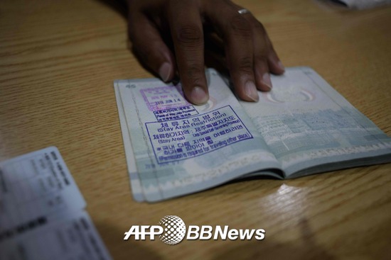 지난 7월4일, 제주에 도착한 예멘 난민 신청자 무하마드 살렘씨가 여권을 보여주고 있다. /AFPBBNews=뉴스1