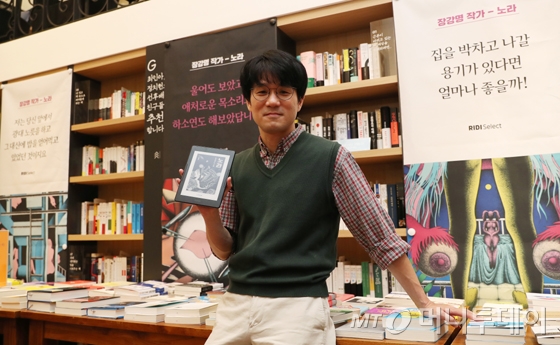 장강명 작가가 리디셀렉트 첫 오리지널 콘텐츠로 연재한 소설 '노라'를 볼 수 있는 전자책 전용 기기 '페이퍼'를 들고 있다./사진=김휘선 기자