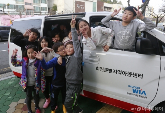회원큰별지역아동센터의 아이들이 7일 경상남도 창원시 마산회원구 회원큰별지역아동센터 앞에서 현대위아가 기증한 ‘드림 카(DREAM CAR)’를 타고 기념사진을 찍고 있다. /사진제공=현대위아<br>
