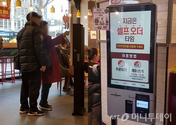 지난 19일 서울 종로구의 한 패스트푸드 전문점. 60대 고객이 '셀프 오더 타임'에 무인 주문기로 주문을 넣다 주변인에게 도움을 청하고 있다. /사진=박가영 기자