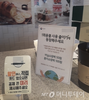 1일 오전 서울의 한 프랜차이즈 제과점 계산대에 '1회용 비닐 봉투 유상 제공' 관련 안내문이 올려져 있다. /사진=방윤영 기자