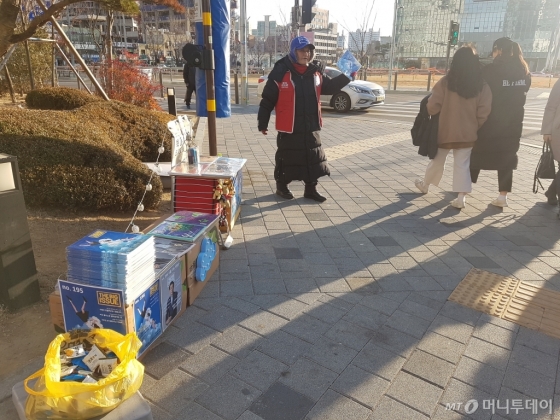 지난 16일 임진희씨(용산역 1번 출구 빅판·53)가 빅이슈 판매에 열을 올리고 있다. 판매대 한켠 노랑 봉투에는 그가 사비로 사둔 과자들이 가득하다. 구매자들에게 감사함을 표현하기 위함이다. /사진=이재은 기자