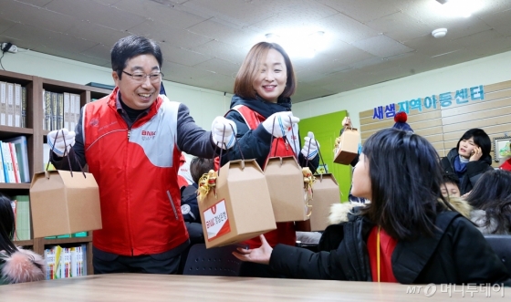 BNK경남은행은 지난 9일 경남과 울산지역에서 ‘10만℃ 릴레이봉사 시즌1-점핑 업(Jumping Up) 생기 올리고’의 세번째 봉사활동으로 ‘복지시설 돌봄활동’을 실시했다. 황윤철 은행장(왼쪽 첫번째)과 임직원들은 새샘지역아동센터를 찾아 새 학기를 앞둔 복지시설 아이들에게 학용품 세트를 선물했다./사진제공=BNK경남은행.<br>
<br>