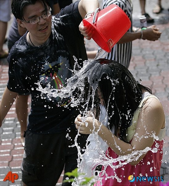 2009년4월12일 말레이시아 쿠알라룸푸르 근방 페탈링 자야에서 열리는 물축제 '송크란 축제'에서 한 남성이 여자친구에게 물을 퍼붓고 있다. 