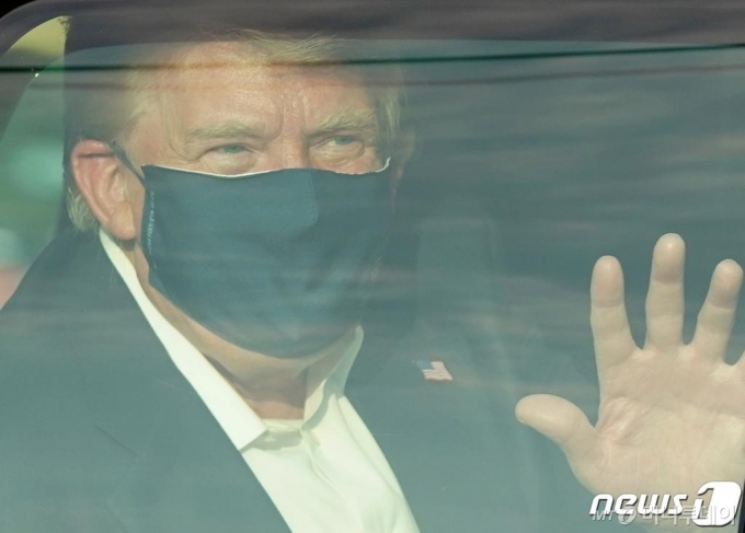 (베데스다 AFP=뉴스1) 우동명 기자 = 도널드 트럼프 미국 대통령이 4일(현지시간) 코로나19로 입원 중인 메릴랜드주 베세스다에 있는 월터 리드 군 병원 밖으로 차를 타고 나와 지지자들 앞을 지나면서 손을 흔들고 있다.  ⓒ AFP=뉴스1