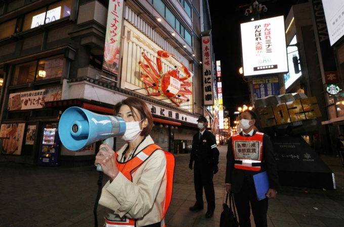 오사카시 관계자들이 지난 15일 번화가인 도톤보리 일대에서 코로나19에 대한 주의를 촉구하고 있다./사진=로이터