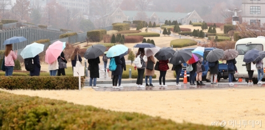 [사진]봄비에 줄지어 선 우산행렬