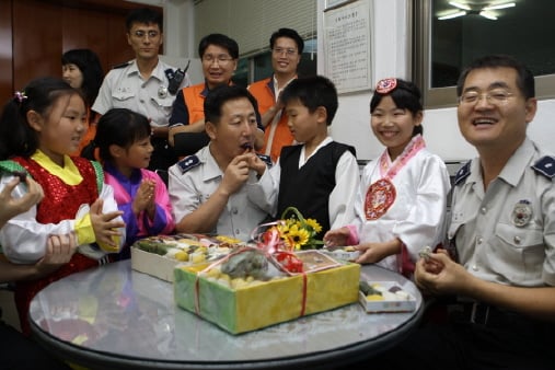 ↑대한생명 사랑모아봉사단원들과 서울SOS마을 어린이들이 20일 양천구 신월1지구대를 방문해 경찰관들과 함께 직접 만든 사랑의 송편을 나누고 있다.