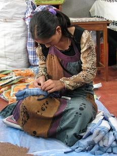 ↑네팔 카투만두의 공정무역 <br>
봉제공장에서 한 직원이 <br>
컴퓨터를 사용할 때 쓰는 <br>
손목 보호대를 만들고 있다. 