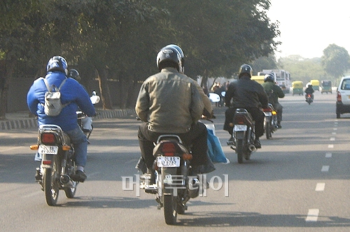 ↑ 오토바이와 오토릭사(사진 왼쪽 노란 차량)가 뉴델리 시내 도로를 달리고 있다.