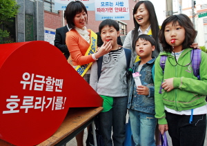 ↑ 중외제약 임직원들이 서울 영등포구에 있는 한 초등학교 앞에서 호신용 호루라기를 나눠주고 있다.