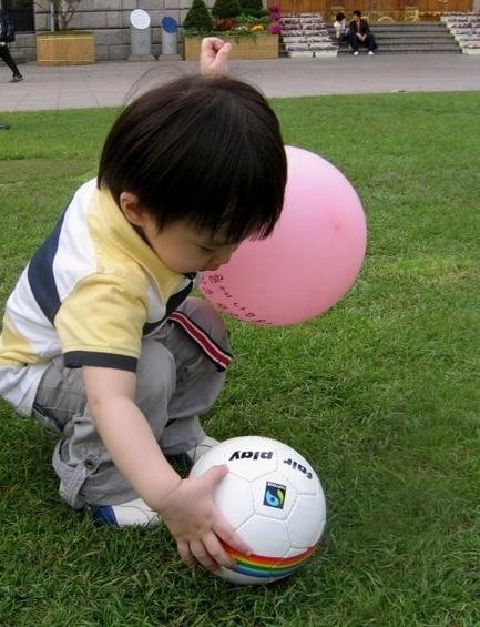 ↑한 아이가 서울시청 앞에서 유아용 '페어플레이-미니'를 가지고 놀고 있다. 이 공은 파키스탄의 아동노동 착취를 막는 데에 기여하는 공정무역 축구공이다. ⓒ공정무역가게 '울림'