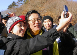 ▲ 지난 1월 신입사원들과 산행에 나선 박삼구 금호아시아나그룹 회장이 여사원과 휴대폰으로 사진을 찍고 있다.