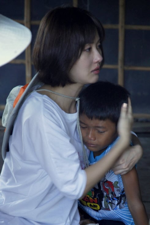 ↑ 부모 없이 3남매만 남은 집에 어느 날 갑자기 불어 닥친 홍수 때문에 놀라 <br>
눈물 흘리는 아이를 김지수가 안아주고 있다. ⓒ사진작가 조남룡<br>
