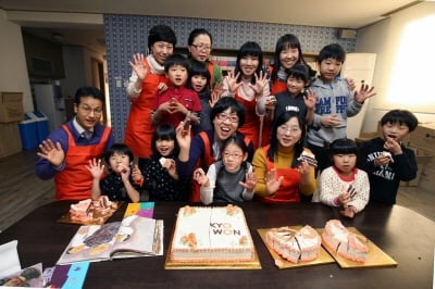 ↑교원그룹 구몬학습 임직원들이 지난 10일 광명보육원을 찾아 아이들과 함께 새로운 CI로 장식된 케이크를 나눠 먹으며 기념 촬영하고 있다. 