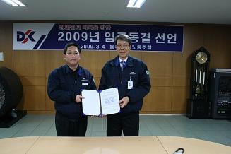 ↑동국제강 박상규 노조위원장(왼쪽)이 4일 동국제강 인천제강소에서 김영철 동국제강 사장에게 임금동결 선언서를 전달하고 있다.