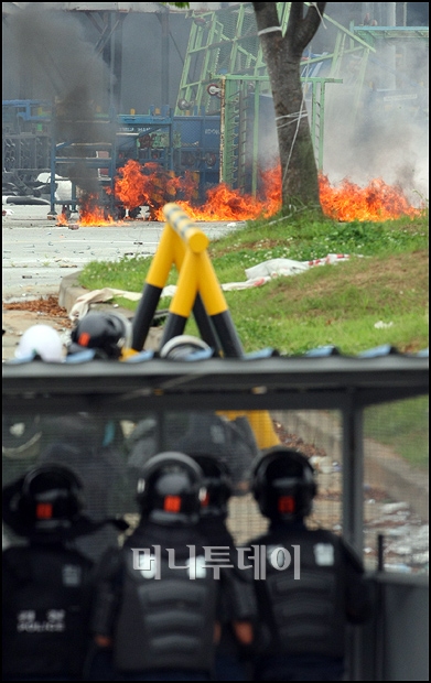 ↑3일 오전 쌍용차 사측이 지게차를 이용해 도장공장 주변 장애물 철거에 나서자 노조측이 화염병을 이용해 이를 저지하고 있다. ⓒ유동일 기자 