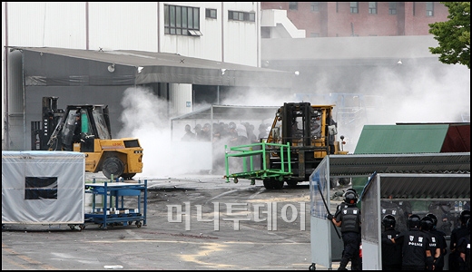 ↑3일 오전 쌍용차 사측이 지게차를 이용해 노조가 설치한 도장공장 인근 장애물들 치우고 있다. ⓒ유동일 기자 