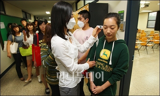 27일 오전 서울 상명대학교 강의실 앞에서 조교들이 체육학부 스포츠 경영학 수업을 받으러 온 학생들의 체온을 재고 있다. 이명근 기자