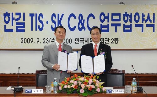 지난 23일 서초동 한국세무사회관에서 SK C&C 김신배 부회장(오른쪽)과 한길TIS 김경수 대표이사(왼쪽)가 업무 협약을 맺고 기념촬영하고 있다.