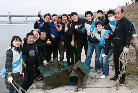 ↑GS건설 임직원들과 전문 잠수부들이 한강 잠실지구에서 정화활동을 벌인 뒤 파이팅을 외치고 있다. @GS건설 