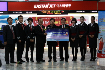 ↑6일 김포공항 국내선 청사 이스타항공 체크인카운터 앞에서 이스타항공 100만 번째 탑승객인 최 한씨(39, 가운데)와 이상직 이스타항공 회장(오른쪽 4번째) 등이 포즈를 취하고 있다.<br>
