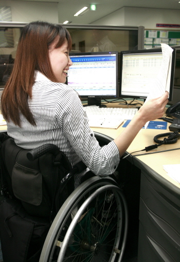 ↑ 포스코가 만든 스틸하우스 설계업체인 포스위드에서 한 장애인이 웃으며 일하고 있다. ⓒ사진제공=한국장애인고용공단