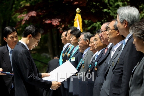 ↑이명박 대통령이 14일 제22회 중소기업 주간을 맞아 청와대 녹지원에서 중소기업 대표와 근로자 등 46명에게 훈장과 포장, 표창장을 전달하고 있다. 