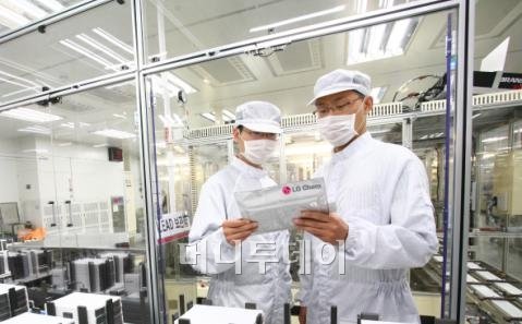 ↑세계 최초·최대규모의 LG화학 오창 전기차 배터리 공장에서 직원들이 생산된 제품을 살펴보고 있다.
