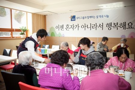 ↑SPC그룹 임직원들이 경기 성남 '정성노인의 집' 무의탁 노인들에게 직접 만든 떡국과 명절 음식을 대접하고 있다. 