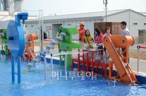 에너지파크에 설치된 에너지체험시설에서 관람객들이 물을 이용해 에너지를 생산하는 기구를 직접 가동해 보고 있다.(사진=유영호기자)