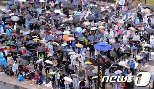 블리자드 엔터테인먼트의 디아블로3 출시를 하루 앞둔 14일 서울 성동구 왕십리 민자역사 비트플렉스 앞 광장에 한정판을 구매하기 위한 시민들이 우산을 쓰고 줄을 서 대기하고 있다. 2012.5.14/뉴스1  News1 양동욱 기자