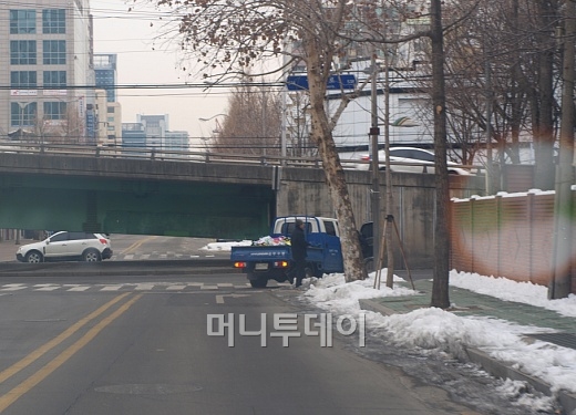 ↑구청 공무원들이 도로옆 불법 현수막을 철거하고 있다.ⓒ송학주 기자