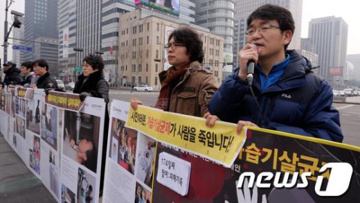 가습기살균제피해자시민모임 회원들이 서울 광화문 광장에서 피해대책을 촉구하는 1인 시위 174회를 맞아 가습기살균제 피해사진을 전시하고 있다.  News1 안은나 기자
