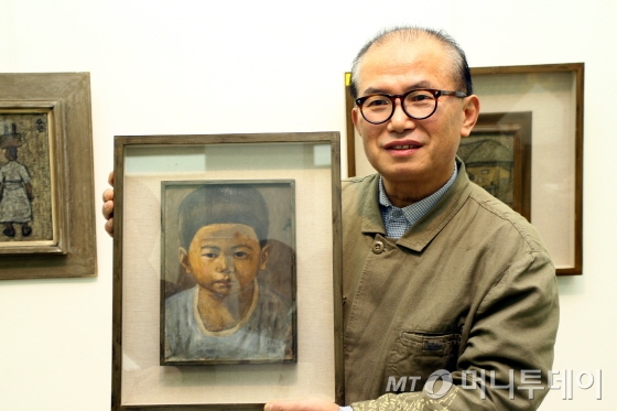 7일 평창동 가나아트센터에서 만난 故박수근 선생의 장남 박성남씨. 아버지가 자신의 어릴시절 모습을 그린 유화그림을 들고 작품 설명을 하고 있다.