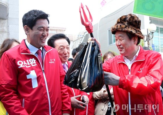 김무성 새누리당 대표(오른쪽)와 오신환 4.29 재보궐선거 관악을 새누리당 후보(왼쪽)가 24일 오전 서울 관악구 신림종합사회복지관 앞에서 열린 바자회에서 물건 구매 후 밝게 웃고 있다. /사진=뉴스1