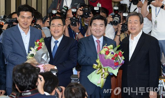  14일 서울 여의도 국회에서 열린 의원총회에서 합의추대된 원유철 원내대표와 김정훈 정책위의장(왼쪽 두번째)이 김무성 대표, 김태호 최고위원과 꽃다발을 들고 당원들을 향해 인사하고 있다. 