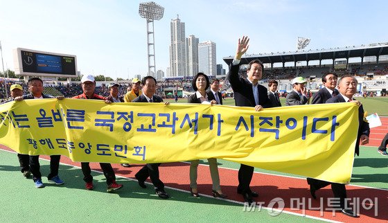 김무성 새누리당 대표가 25일 오전 서울 양천구 목동운동장에서 열린 제33회 대통령기 이북도민 체육대회에서 황해도중앙도민회 관계자들과 함께 '역사 바로세우기는 올바른 국정교과서가 시작이다'라고 적힌 현수막을 들고 있다. /뉴스1