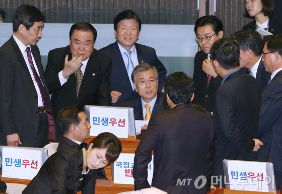  27일 박근혜 대통령의 시정연설이 열리는 국회 본회의장에 입장한 새정치민주연합 의원들이 '국정교과서 반대', '민생우선'이라고 적힌 스티커를 모니터 뒷면에 붙인 것을 정의화 국회의장이 문제삼자, 문재인 대표와 이종걸 원내대표 등 지도부가 대책을 논의하고 있다. 2015.10.27/뉴스1  