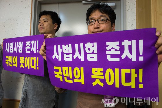  사법시험 존치를 위한 고시생 모임 회원들이 2일 서울 여의도 국회 의원회관에서 대한법학교수회·대한변호사협회 주최로 '법학교육의 상생 발전과 법조인 양성제도의 개혁' 토론회에서 사법시험 존치를 촉구하는 현수막을 들고 있다. 2015.10.2/사진=뉴스1