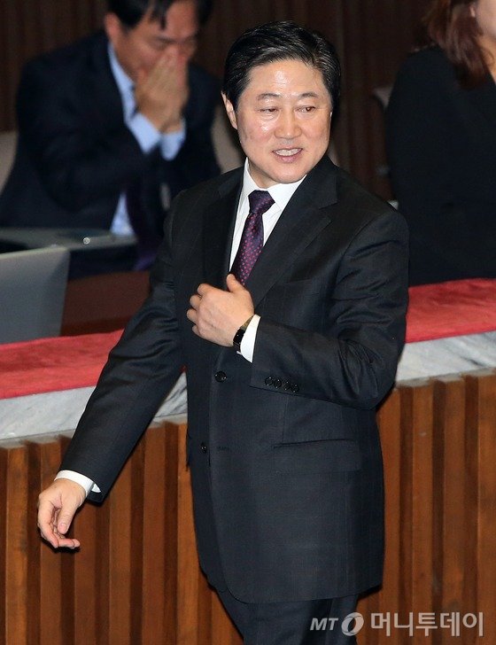  해양수산부 장관 직을 마치고 여의도로 컴백한 새누리당 유기준 의원이 12일 국회에서 열린 본회의에서 의원들과 인사를 나누며 옷매무새를 만지고 있다. 2015.11.12/뉴스1  