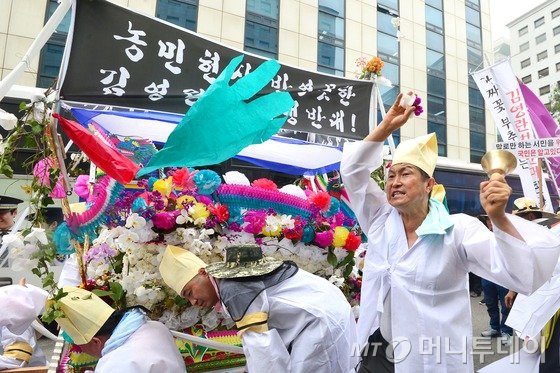  화훼협회 회원들이 29일 오후 서울 영등포구 국회의사당 앞에서 열린 '부정 청탁 및 금품 수수 금지법(김영란법) 시행령 반대 집회'를 마친 뒤 상여를 메고 새누리당사 앞을 행진하던 중 상여를 부수며 청탁금지법 개정을 요구하고 있다.2016.6.29/뉴스1  