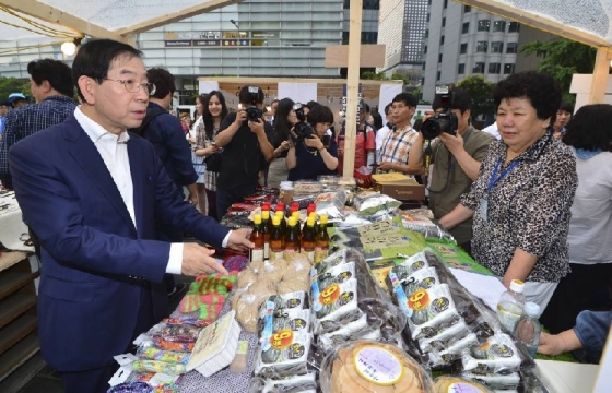 박원순 서울시장이 29일 오후 서울 청계광장에서 열린 서울 사회적경제 주간 행사에서 사회적 기업 제품을 살펴보고 있다.사회적기업의 날(7월 1일)과 협동조합의 날(7월 2일)을 맞아 30일까지 열리는 이번 행사에서는 사회적기업이 만든 제품과 음식 등을 만날 수 있다. 2016.6.29/뉴스1