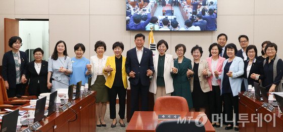 서울 여의도 국회에서 열린 여성가족위원회 전체회의에서 남인순 위원장과 여야 간사을 비롯한 의원들이 손을 잡고 포즈를 취하고 있다. 2016.6.17/뉴스1