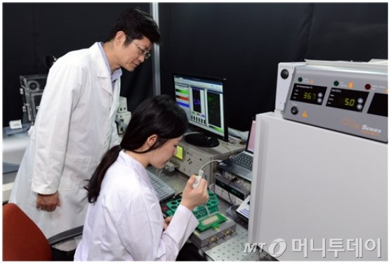 연구팀이 혈관투과성 측정을 위해 세포를 기판에 올려놓고 있다./사진제공=한국표준과학연구원<br />
